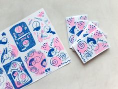 some pink and blue stickers sitting on top of a table