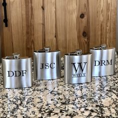 four stainless steel flasks sitting on top of a counter