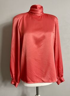 Beautiful vintage satin blouse by Alternatives in size UK 12 High neck Open cowl back Padded shoulder Long sleeve In coral satin Great used condition Elegant High Neck Silk Top, Fitted Silk High Neck Top, Pink Satin Top For Work, Pink Satin Top For Evening, Chic High Neck Silk Top, Chic Silk High Neck Top, Silk High Neck Top For Evening, Formal Pink Satin Tops, Elegant High Neck Satin Top