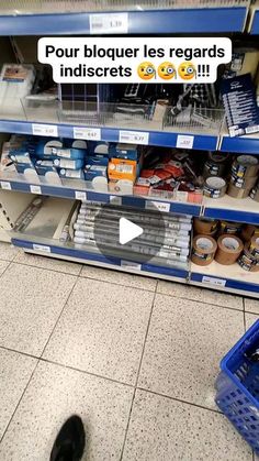 a black cat sitting on the floor in front of a store shelf