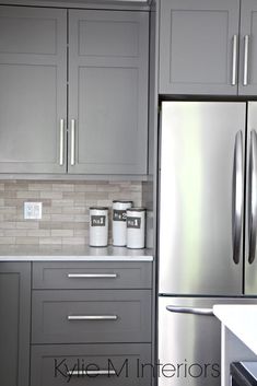 a kitchen with gray cabinets and stainless steel appliances