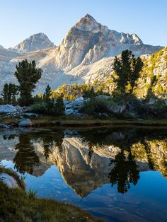 the mountains are reflected in the still water