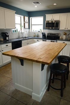 a kitchen island with two stools in front of it