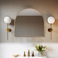 a white sink sitting under a mirror next to a wall mounted faucet in a bathroom