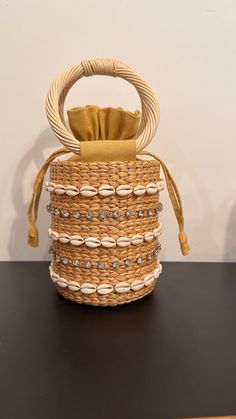 Our Leah Bag is our new favorite mini bag for spring and summer! With shell and stone embellished detail on a simple straw bag with round handles, this handheld adds style and personality to any outfit. Material: 100% Raffia, 100% Cotton Lining, Shell and Stone Detail Spot Clean with Damp Cloth Chic Beach Shoulder Bag With Round Handle, Chic Shoulder Bag With Round Handle For Beach, Elegant Bucket Bag With Braided Handles For Beach, Beach Tote Bag With Pearl Handle, Natural Beach Bag With Pearl Handle, Summer Straw Bag With Pearl Handle In Natural Color, Chic Straw Beach Bag With Pearl Handle, Summer Beige Straw Bag With Pearl Handle, Chic Straw Bag With Pearl Handle For Beach