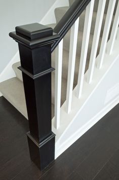 a black and white banister next to a stair case