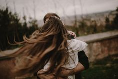 a woman with long hair walking in the grass