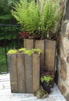 three wooden planters with plants growing out of them