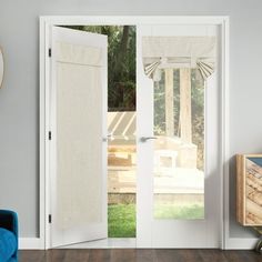 an open white door in a living room next to a blue chair and wooden table