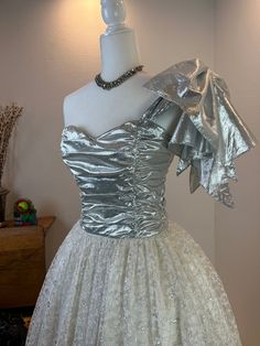 1980's Gunne Sax / Jessica McClintock / 1980s prom dress / vintage prom dress / Gunne Sax dress / Gunne Sax Prom / Jessica McClintock prom  This beauty is classic a 1980's Gunne Sax by Jessica McClintock princess party dress. She has a gorgeous silver lame bodice fabric that shimmers. Her lace skirt has silver threads woven into it for extra glamor. She has a boned bodice, with a full and long 3 layer skirt. But the ultimate piece of beauty is the enormous silver lame shoulder bow that drapes off your shoulder. This added touch makes this dress next level. This dress is gorgeous in person, please check out her video. FYI: these lame Gunne Sax dresses are hard to find!  Measurements provided are flat and have been doubled. vintage size 9 Bust 32/33" Waist 27" Hips free Length from bodice to 1990s Prom Dress, 1990s Prom, 1980s Prom Dress, 1980s Prom, Prom Dress Vintage, Princess Party Dress, Vintage Prom Dress, Sax Dress, Layer Skirt