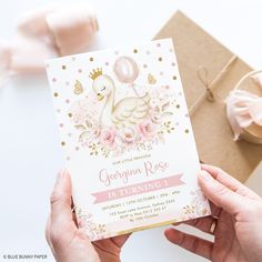 a person holding up a birthday card with a swan on it and pink flowers around the edges