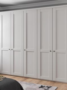 a white wardrobe with doors and drawers in a room