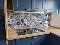 a kitchen with blue cabinets and tile backsplash