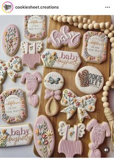 some decorated cookies are on a wooden board and there is a sign that says baby congratulations