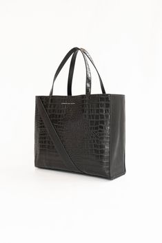 A Christina Karin Exclusive - The Marais Python Tote Inspired by Paris' fashion focused Le Marais district, this python leather tote bag combines modern architectural details with textural intrigue. Generous carry all sizing allows it to fit all your essentials and then some. Make it your travel partner or pair it with a power suit for ease and sophistication. We've designed this tote to go the distance in every modern woman's real life. We invite you to discover the essence of everyday luxury. Rectangular Crocodile Pattern Shoulder Bag For Work, Rectangular Crocodile Pattern Work Bag, Modern Black Bags With Crocodile Pattern, Modern Crocodile Pattern Shoulder Bag For Daily Use, Modern Shoulder Bag With Crocodile Pattern For Daily Use, Modern Rectangular Bags With Crocodile Pattern, Modern Crocodile Pattern Shoulder Bag, Modern Shoulder Bag With Crocodile Pattern, Modern Crocodile Pattern Tote Shoulder Bag