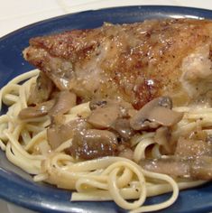 a blue plate topped with meat and noodles