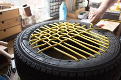 a person is working on an object made out of tire rims and rubber tires