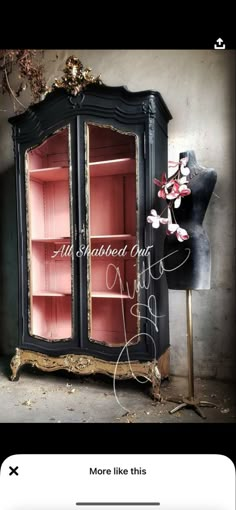 an old black china cabinet with pink glass doors