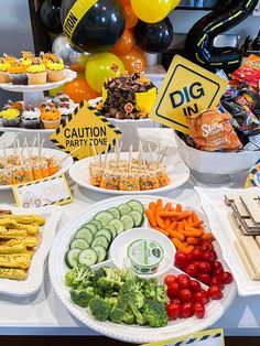 a table filled with lots of food and balloons