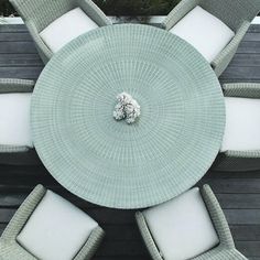 an overhead view of a table and chairs with white cushions on the outside patio area