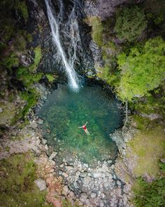 a person in a red kayak near a waterfall