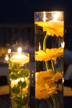 two vases filled with water and yellow flowers