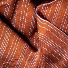 an orange and white striped fabric with small squares on it's edges, close up