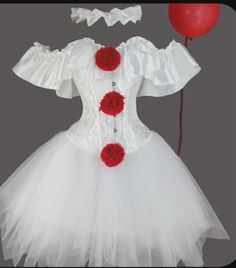 a white dress with red flowers on it and a balloon attached to the waistline