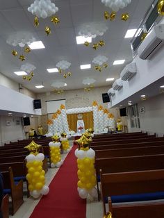 a church decorated with balloons and streamers in the shape of gold, white and silver stars