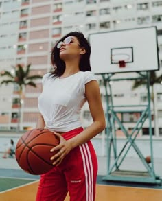 a woman holding a basketball in her hands