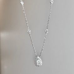 One (1) 14K white gold diamond pear shape halo necklace 55/100CTW prong set with (1) pear shape diamond 25/100CT of fine (G-H) color and (SI) clarity surrounded by (14) round brilliant cut diamond of fine (G-H) color and (VS) clarity with (4) bezel set round brilliant cut in the 18inch chain with a lobster clasp 30/100CTW. Fine Jewelry Platinum Pear-shaped Diamond Necklace, Platinum Pear-shaped Diamond Necklace, Classic Teardrop Diamond Necklace With Single Cut Diamonds, Classic Teardrop Brilliant Cut Diamond Necklace, Classic Teardrop Pendant Diamond Necklace With Single Cut Diamonds, Classic Diamond Necklace With Single Cut Teardrop Pendant, Elegant Teardrop Pendant Diamond Necklace With Vvs Clarity, Fine Jewelry White Gold Teardrop Diamond Necklace, White Gold Brilliant Cut Drop Diamond Necklace