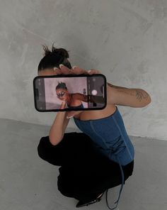 a woman is taking a selfie with her cell phone while sitting on the floor