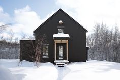 a black house with snow on the ground