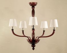 a chandelier with five lamps and shades on the bottom one is red, while the other two are white