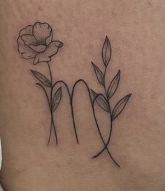 a woman's lower back tattoo with two flowers on her left side ribcage