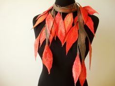 a black mannequin with red and orange leaves on it