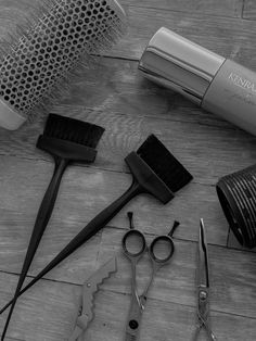 black and white photograph of hair accessories on wooden floor with blow dryer in background