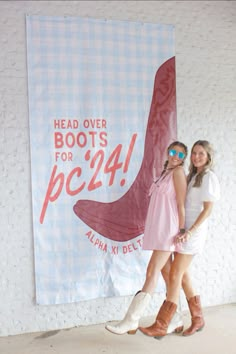 two girls standing in front of a sign that says head over boots for pc4