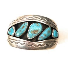 Pre-owned BRAND : Nizhoni Traders LLC TYPE : Bracelet COLOR : Blue THEME : Beauty STYLE : Cuff BASE METAL : Sterling Silver METAL : Silver MAIN STONE : Turquoise VINTAGE : Yes Gorgeous Old Pawn Vintage Navajo Kingman Turquoise and Sterling Silver Cuff Bracelet. Absolutely beautiful craftsmanship! This piece has an inside circumference of 5 1/4 inches with a 1 inch gap. The width is 1 5/8 inches. Signed by the artist. Really great cuff! Thank you for visiting our store, please let us know if you Southwestern Blue Cuff Jewelry, Blue Artisan Cuff Jewelry, Artisan Blue Cuff Jewelry, Blue Gemstone Cuff Bracelet, Blue Theme, Sterling Silver Cuff Bracelet, Kingman Turquoise, Vintage Navajo, Beauty Style