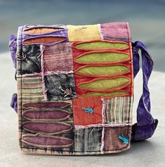 a multicolored patchwork purse sitting on the ground