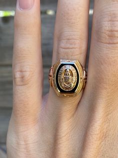 a close up of a person's hand with a gold ring on their finger