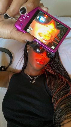 a woman laying on top of a bed holding a cell phone