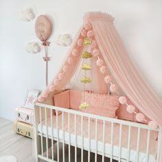 a baby crib with pink and gold decorations