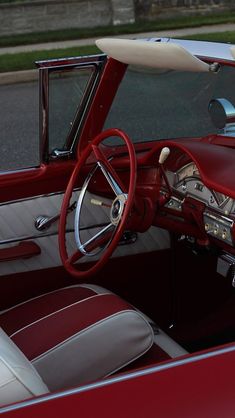 the interior of a classic car with red and white leather