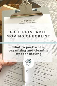 a clipboard with the text free printable moving checklist on it and a hand holding a clipboard