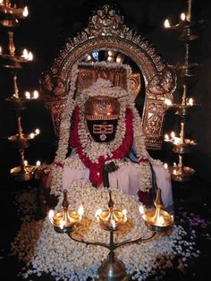 the idol is surrounded by flowers and candles