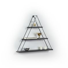 a black shelf with candles on it and a white wall in the backround