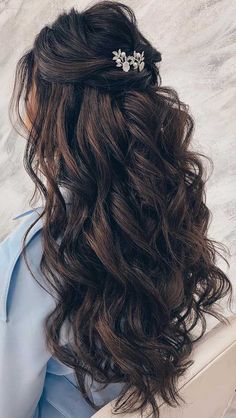 the back of a woman's head with wavy hair and a comb in it