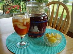 a pitcher and glass filled with liquid sitting on top of a table