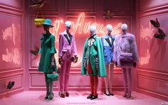 three mannequins dressed in brightly colored clothing and hats with butterflies on the wall behind them